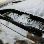 Detailed image of a sleek car being washed with foam, showcasing the car's design and cleanliness. - Photo by Luke Miller on Pexels