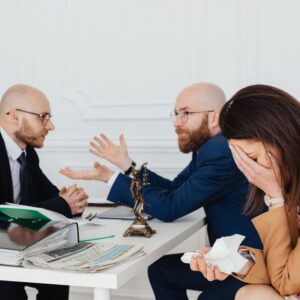 A lawyer mediates an emotional settlement discussion with a distressed couple in a legal office. - Photo by https://kaboompics.com/ on Pexels
