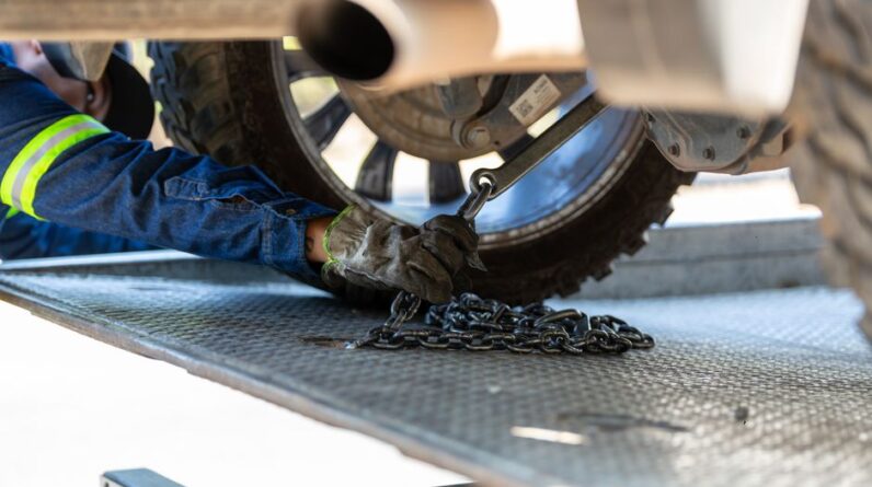 Mechanic securing a vehicle on a service platform with a chain for safe towing. - Photo by Jonathan Reynaga on Pexels